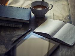 木桌上的笔记本和咖啡平板