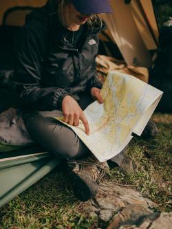 女人坐在帐篷里观看地图