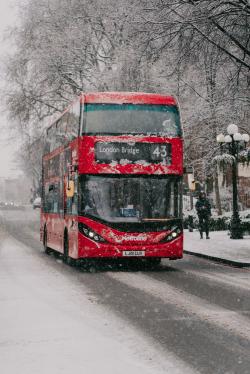 冬天下雪街上的红色巴士