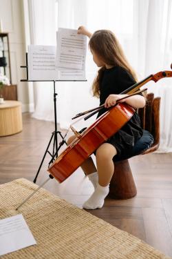 换乐谱练习大提琴的小女孩