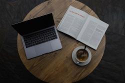 桌子上一杯咖啡一本书一个笔记本电脑