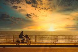 骑着自行车在海边看落日