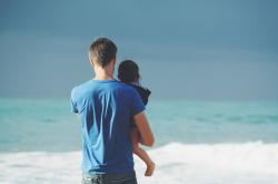爸爸海边抱着女儿背影
