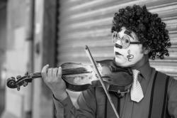 拉小提琴的马戏团小丑黑白照片